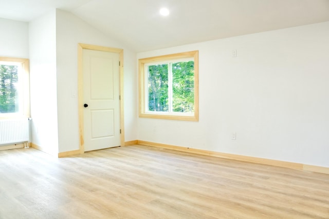 284 Flanders Pond Rd, Sullivan, ME 04664 - unfurnished room featuring radiator heating unit, healthy amount of natural light, light wood-type flooring, and lofted ceiling
