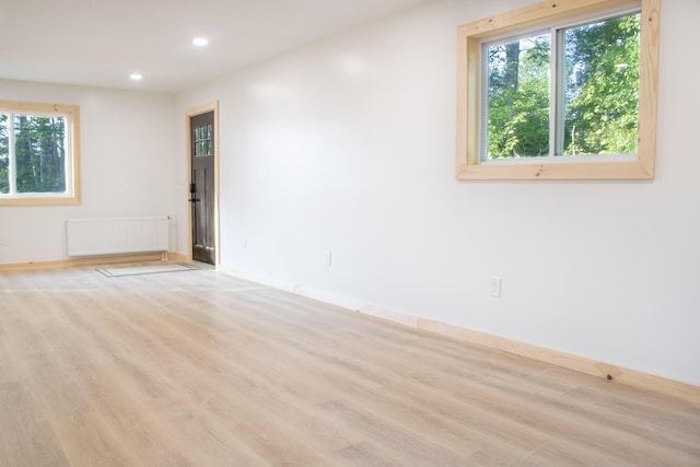 284 Flanders Pond Rd, Sullivan, ME 04664 - spare room with radiator heating unit, plenty of natural light, recessed lighting, and wood finished floors
