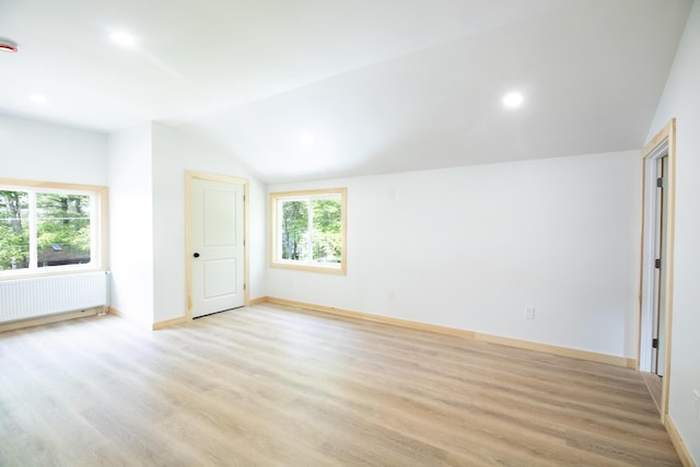 284 Flanders Pond Rd, Sullivan, ME 04664 - empty room with radiator heating unit, lofted ceiling, light wood finished floors, and recessed lighting