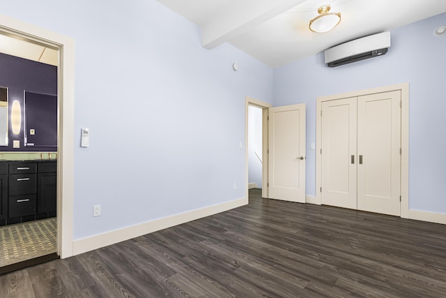 unfurnished bedroom featuring dark wood-type flooring, a wall unit AC, a closet, and beamed ceiling