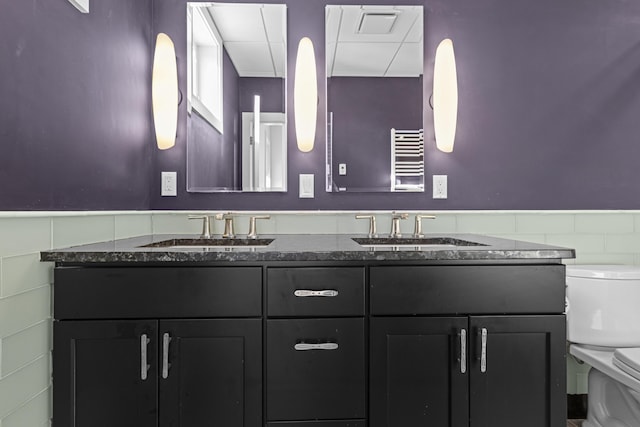 bathroom featuring radiator heating unit, vanity, and toilet