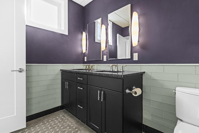 bathroom with tile walls, toilet, tile patterned floors, and vanity