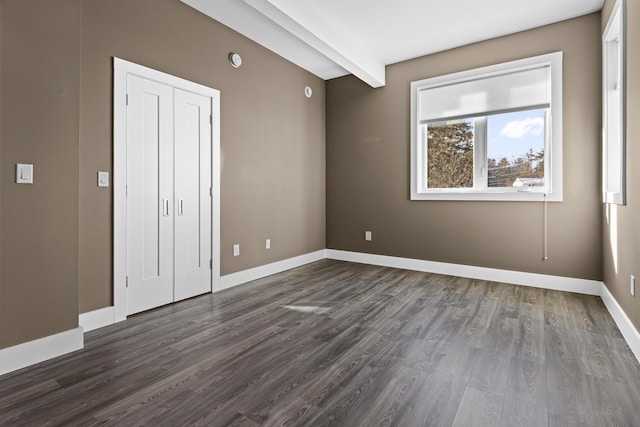 unfurnished bedroom with dark hardwood / wood-style flooring and beam ceiling