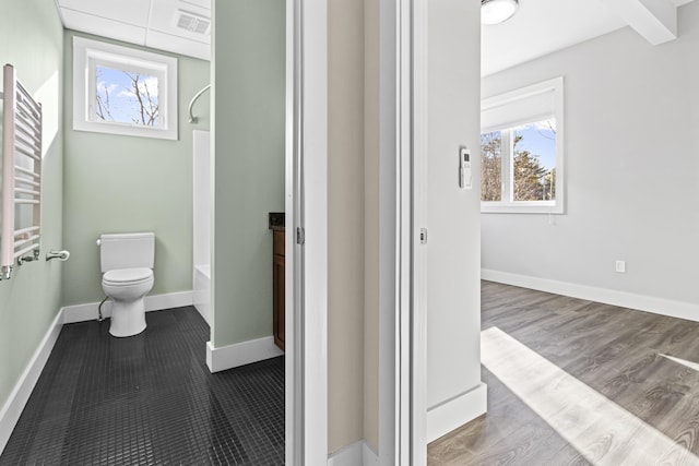 bathroom with wood-type flooring, radiator heating unit, plenty of natural light, and toilet