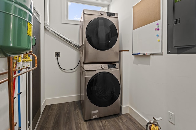 laundry area featuring electric panel, dark wood-type flooring, and stacked washer and dryer