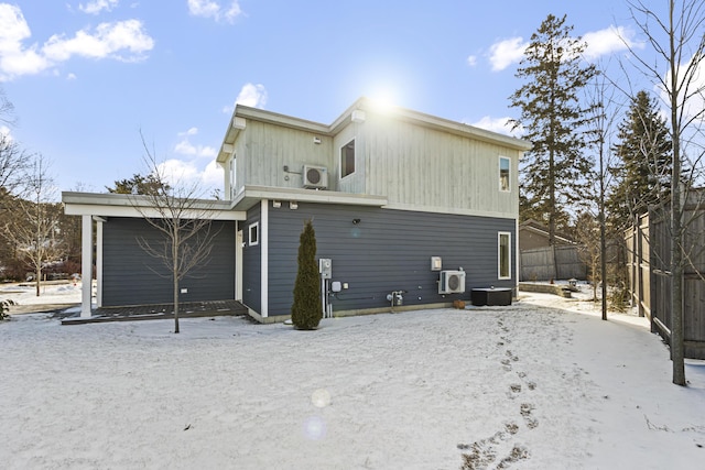 snow covered property with central air condition unit