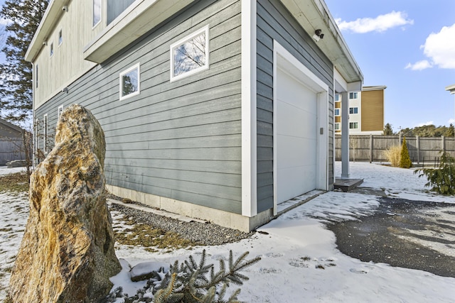 view of snowy exterior with a garage