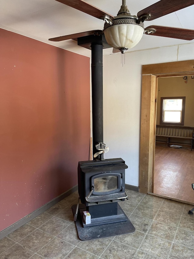 details with ceiling fan and a wood stove