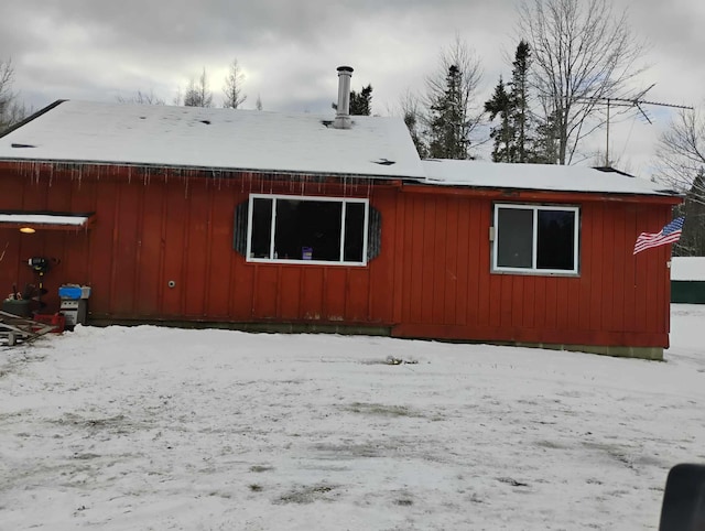 view of snow covered rear of property