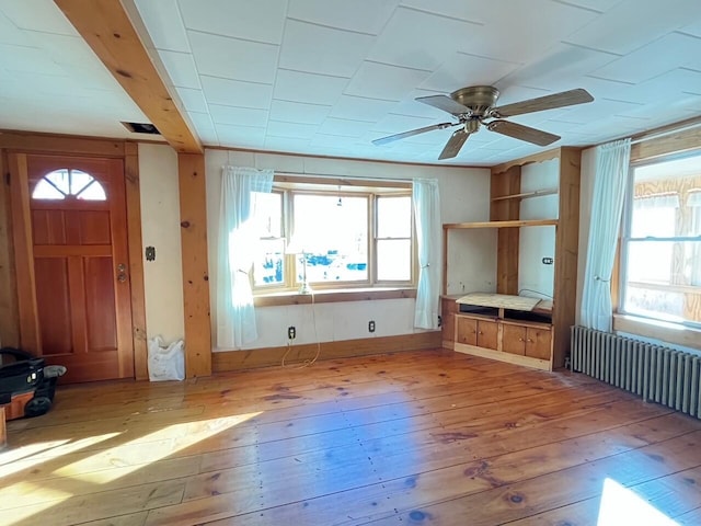 interior space with ceiling fan, light hardwood / wood-style flooring, and radiator heating unit