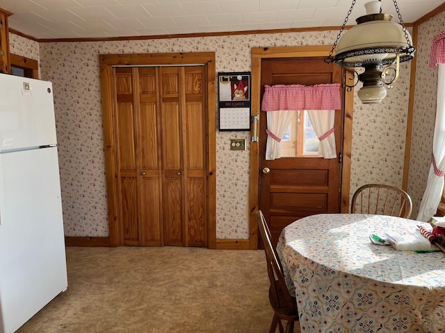 dining area with carpet and crown molding