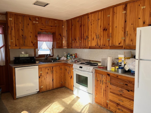 kitchen featuring sink, white appliances, and tasteful backsplash