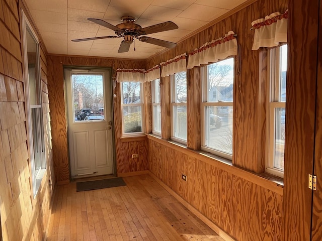 unfurnished sunroom with ceiling fan