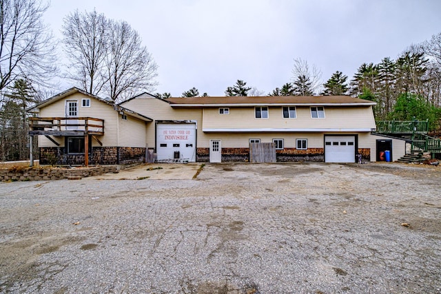 front facade with a wooden deck and a garage