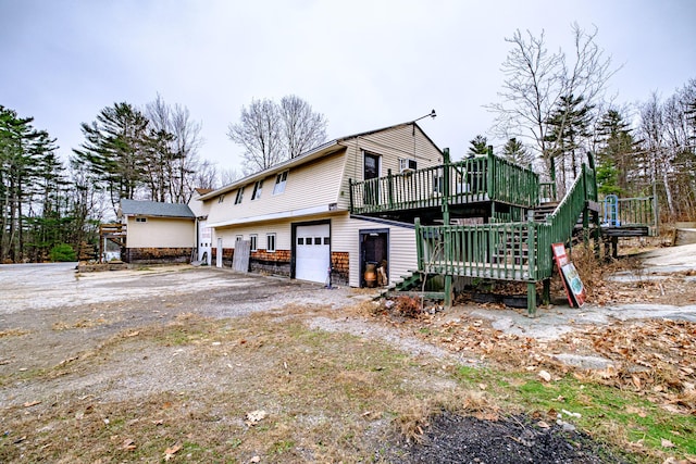 view of side of property featuring a wooden deck and a garage