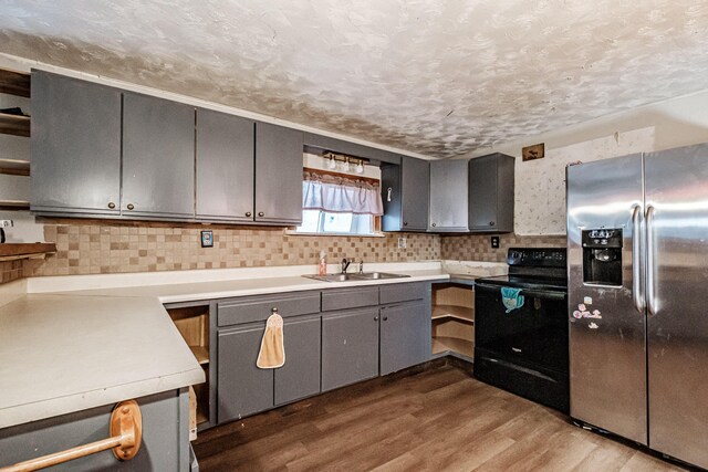 kitchen featuring sink, electric range, light wood-type flooring, a textured ceiling, and stainless steel fridge with ice dispenser