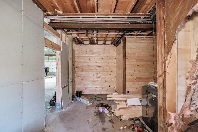 misc room featuring concrete floors and wooden walls