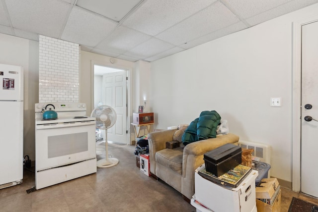 interior space featuring white cabinetry, white appliances, and a paneled ceiling