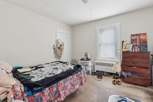 bedroom featuring radiator heating unit and a closet