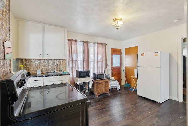 kitchen with electric stove, sink, dark wood-type flooring, white cabinets, and white fridge