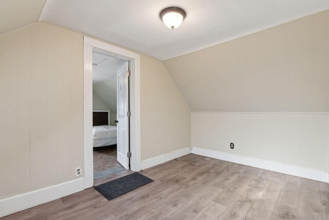 bonus room with lofted ceiling and light hardwood / wood-style floors