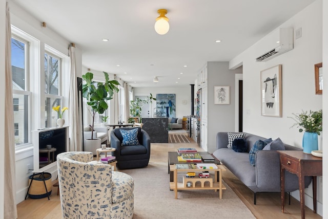 living room with light hardwood / wood-style floors and a wall mounted air conditioner