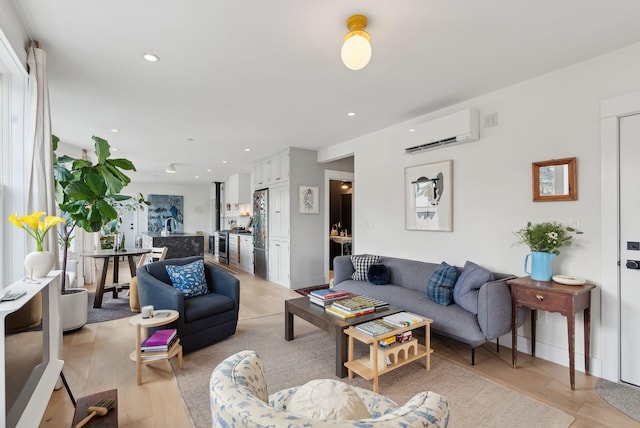 living room with an AC wall unit and light hardwood / wood-style flooring