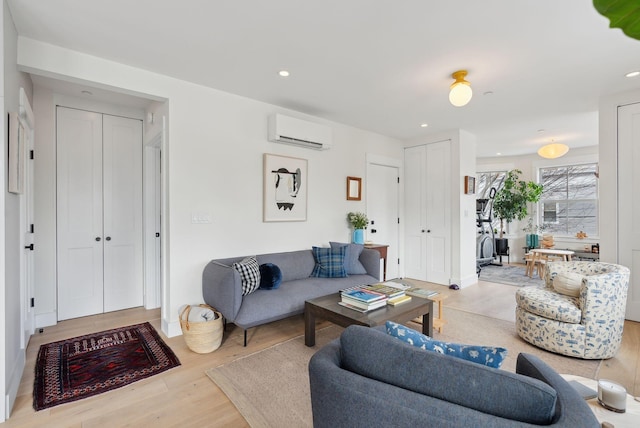 living room featuring a wall unit AC and light hardwood / wood-style floors