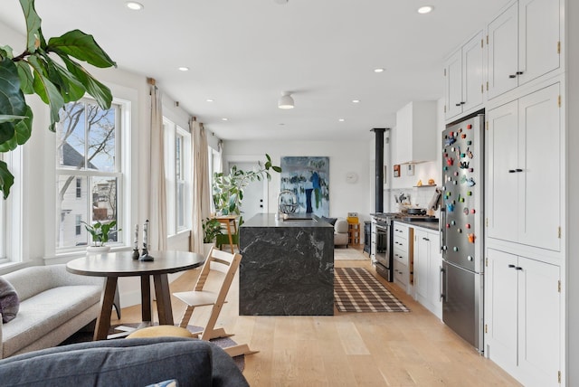 kitchen with appliances with stainless steel finishes, light wood-type flooring, and white cabinets