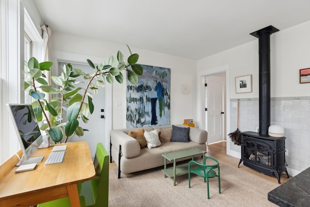 living room with light hardwood / wood-style flooring and a wood stove