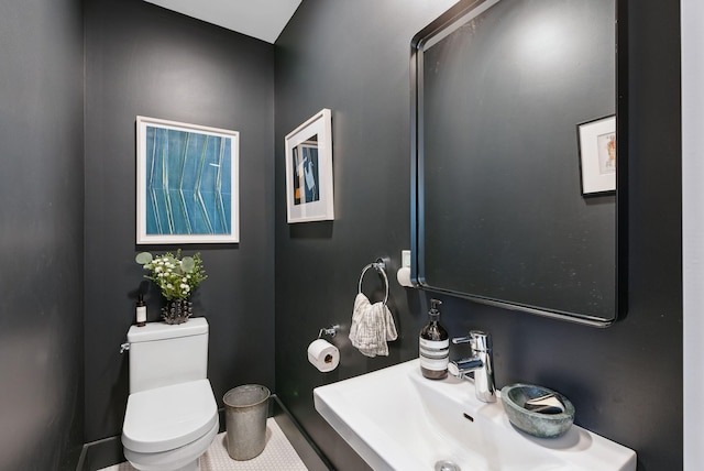 bathroom featuring toilet, tile patterned floors, and sink