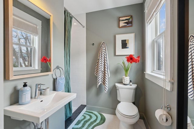 bathroom featuring sink, a wealth of natural light, curtained shower, and toilet