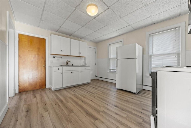 kitchen with sink, white cabinetry, a paneled ceiling, and white fridge