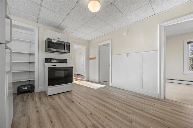 kitchen featuring white appliances, light hardwood / wood-style flooring, white cabinets, a drop ceiling, and a baseboard radiator