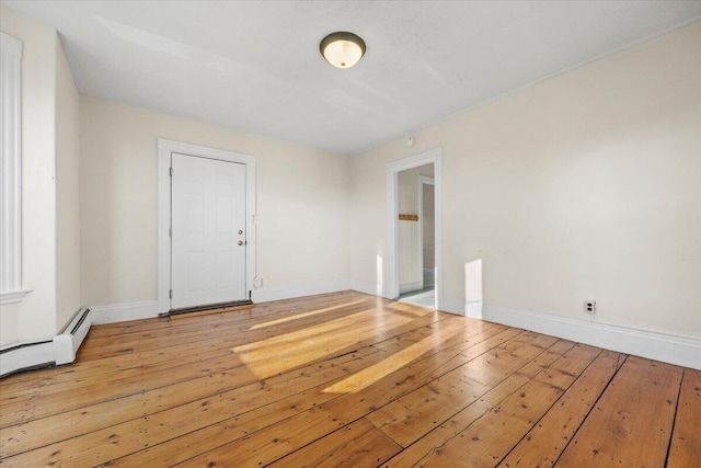 unfurnished room with baseboard heating and hardwood / wood-style floors