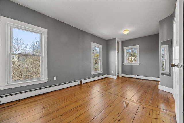 unfurnished room with light wood-type flooring and a baseboard radiator