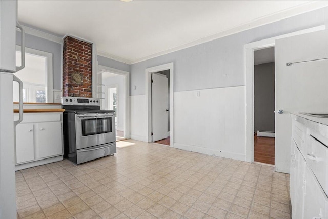 kitchen featuring a baseboard heating unit, ornamental molding, white cabinets, and stainless steel range with electric stovetop