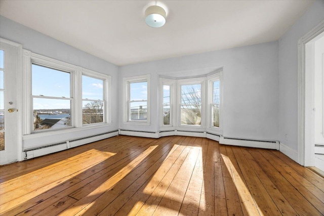 unfurnished sunroom with a baseboard heating unit