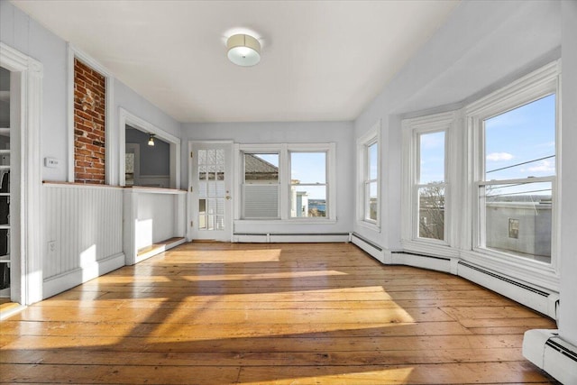 unfurnished sunroom featuring baseboard heating