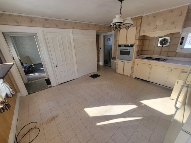 kitchen featuring light tile patterned floors, stainless steel oven, white electric cooktop, decorative light fixtures, and a chandelier