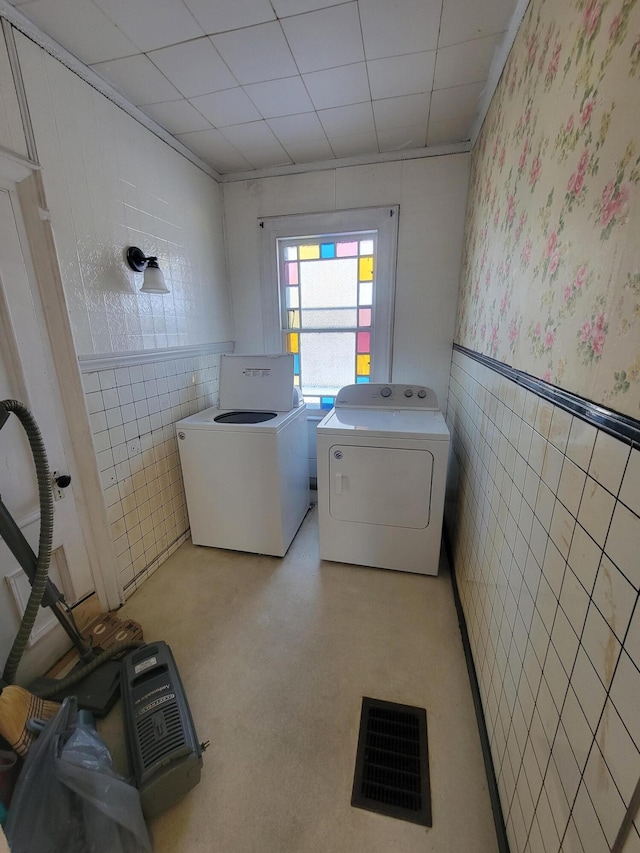 washroom featuring tile walls and independent washer and dryer