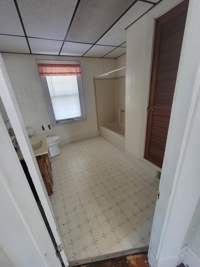 full bathroom with toilet, vanity, a drop ceiling, and washtub / shower combination