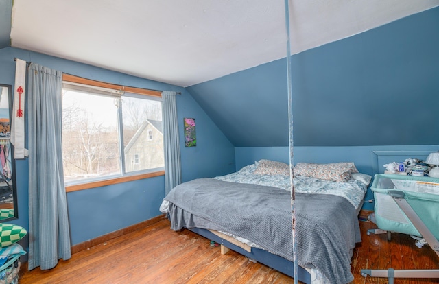 bedroom featuring hardwood / wood-style floors and vaulted ceiling