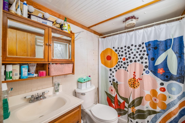 bathroom with toilet, vanity, and curtained shower