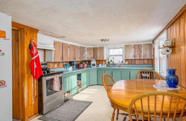 kitchen with stainless steel range with electric cooktop, white fridge, and green cabinetry