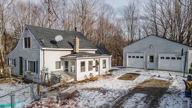 view of snow covered exterior with a garage and an outbuilding