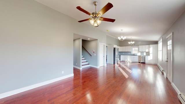 unfurnished living room featuring hardwood / wood-style flooring, ceiling fan with notable chandelier, baseboard heating, and high vaulted ceiling