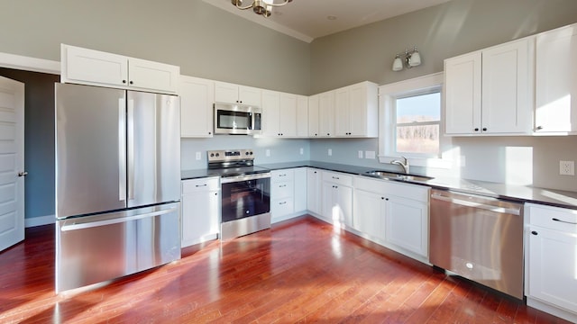 kitchen with stainless steel appliances, white cabinetry, and sink