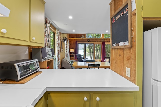 36 Storer Rd, Bremen, ME 04551 - kitchen with freestanding refrigerator, light countertops, wood walls, green cabinets, and recessed lighting