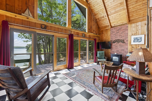 36 Storer Rd, Bremen, ME 04551 - living area with high vaulted ceiling, wooden walls, tile patterned floors, a water view, and a wooden ceiling with exposed beams